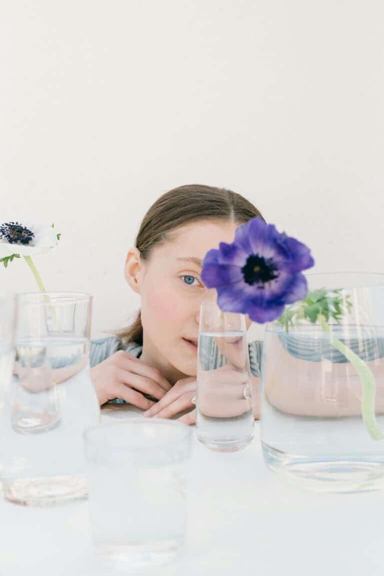 Being autistic is... for example, being fascinated by the little things, like the woman in this picture, who is watching a violet flower that hides a part of her face.