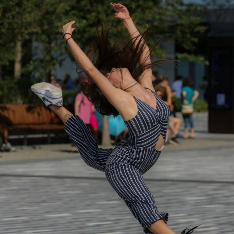 Woman dancing freely in a public space, expressing joy and movement, symbolizing neurodivergent joy, freedom and unmasked self-expression